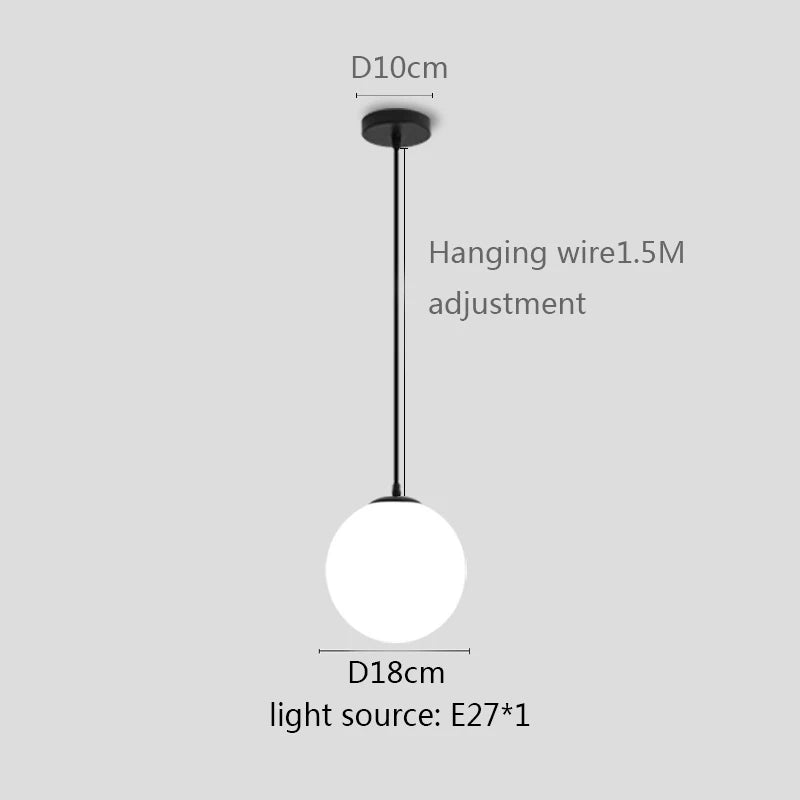Modern glass globe pendant light with gold finish hanging above a contemporary dining table.