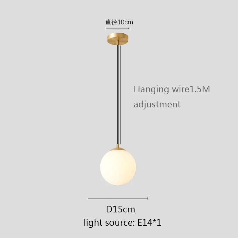 Modern glass globe pendant light with gold finish hanging above a contemporary dining table.