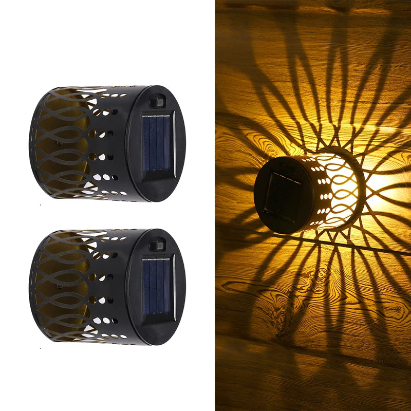 Modern waterproof solar projection LED wall light casting a decorative light pattern on an outdoor garden wall.