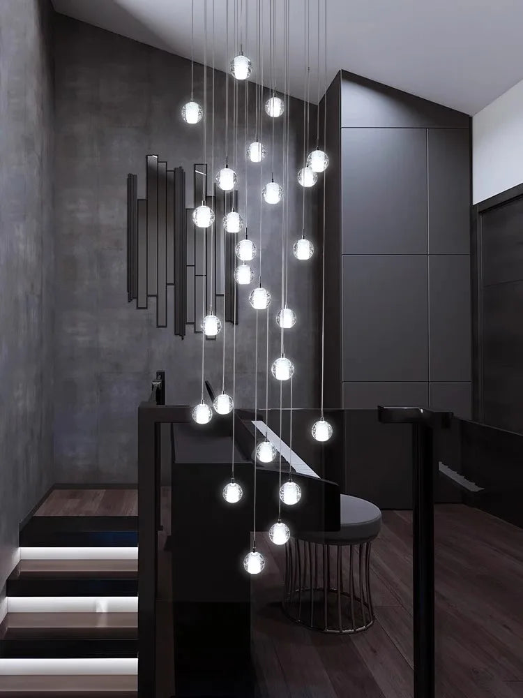 Modern spiral crystal LED chandelier cascading down a luxury staircase in a contemporary home.