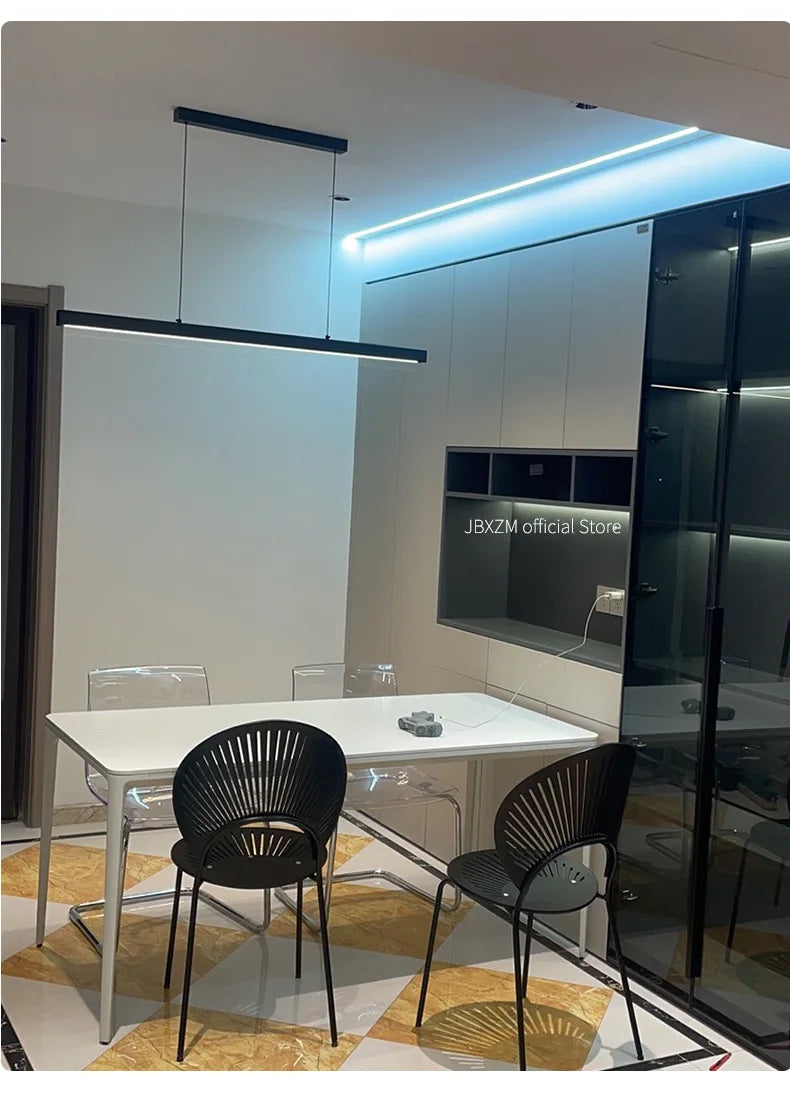 Modern linear LED pendant light suspended above a dining table in a contemporary dining room.