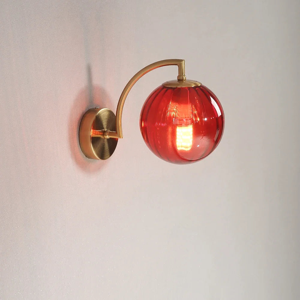 Modern Nordic glass LED wall sconce mounted beside a bed in a contemporary bedroom with warm ambient lighting.