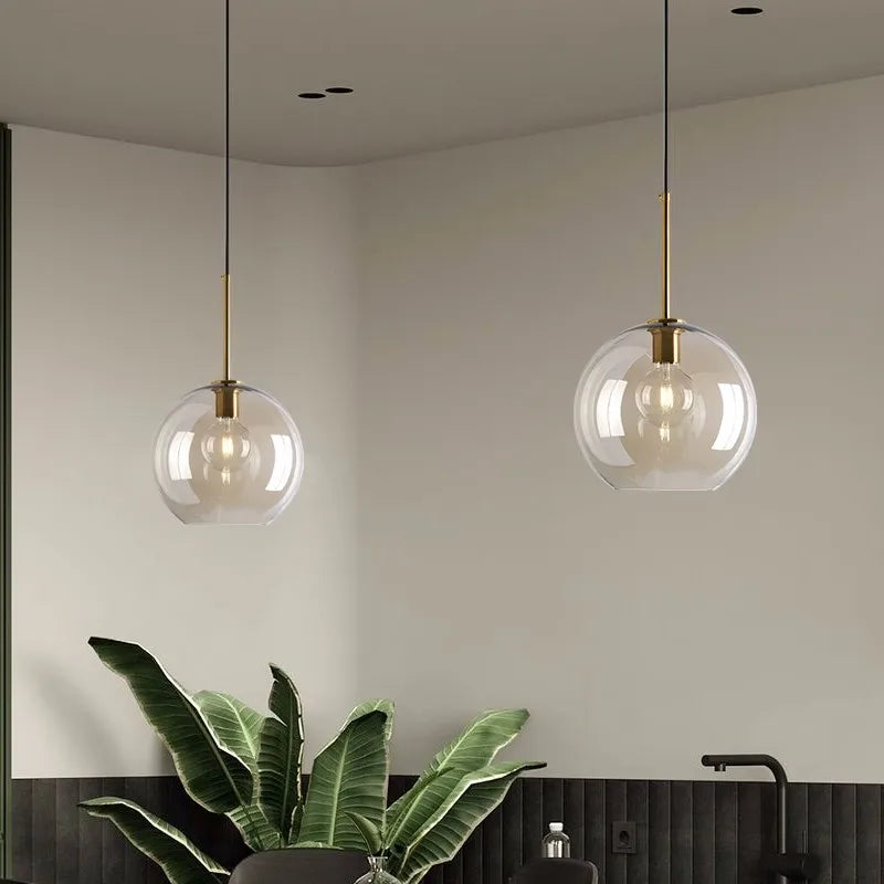 Nordic Glass Pendant Light hanging in a modern kitchen with green plants and stylish decor.