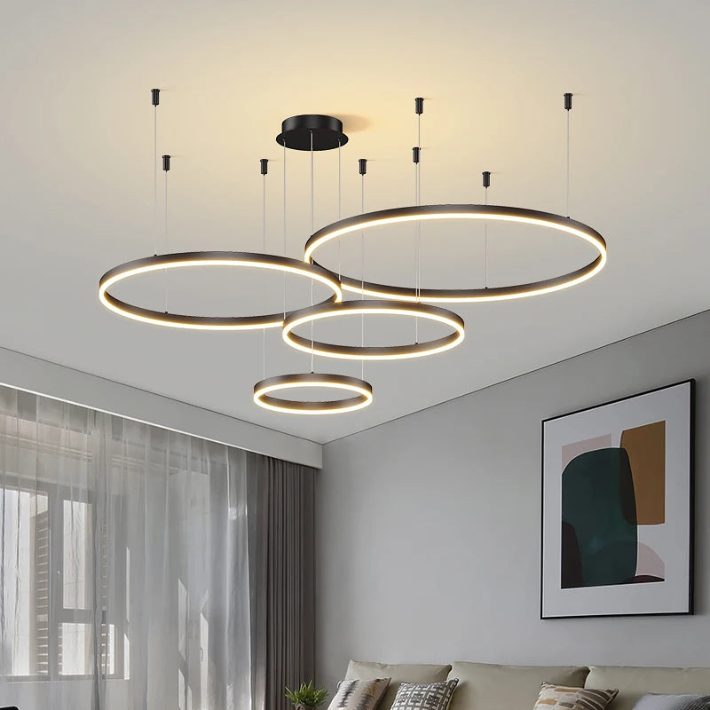 Modern LED circular ring chandelier installed above a dining table in a contemporary luxury home.