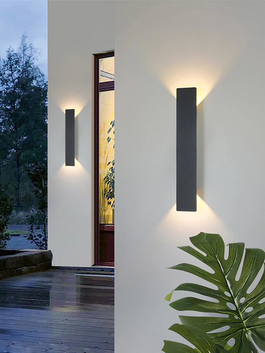Modern black aluminum IP65 waterproof LED wall light mounted on an exterior wall with an up-and-down lighting effect.