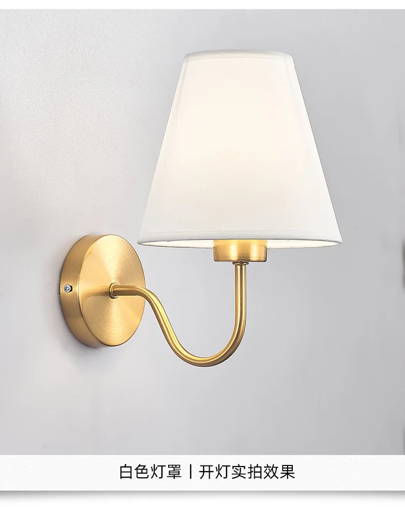 Modern fabric wall sconce installed beside a bed in a contemporary bedroom with warm ambient lighting.