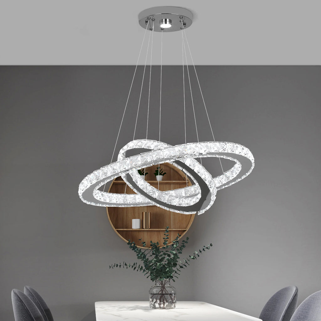 Luxury crystal ring LED chandelier suspended above a modern dining table in an elegant contemporary home.