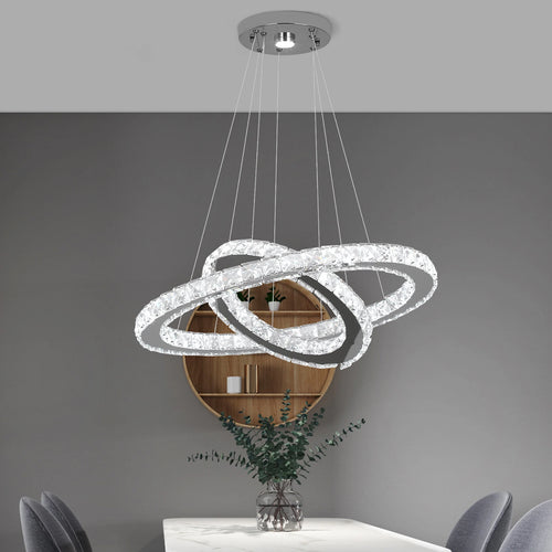 Luxury crystal ring LED chandelier suspended above a modern dining table in an elegant contemporary home.