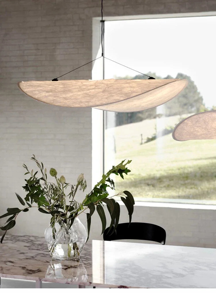 Nordic modern LED pendant light hanging above a dining table in a contemporary living room.