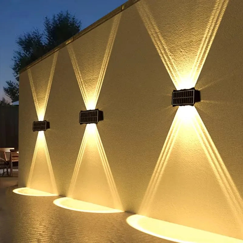 Modern waterproof solar LED wall light installed on an exterior wall illuminating a garden pathway.