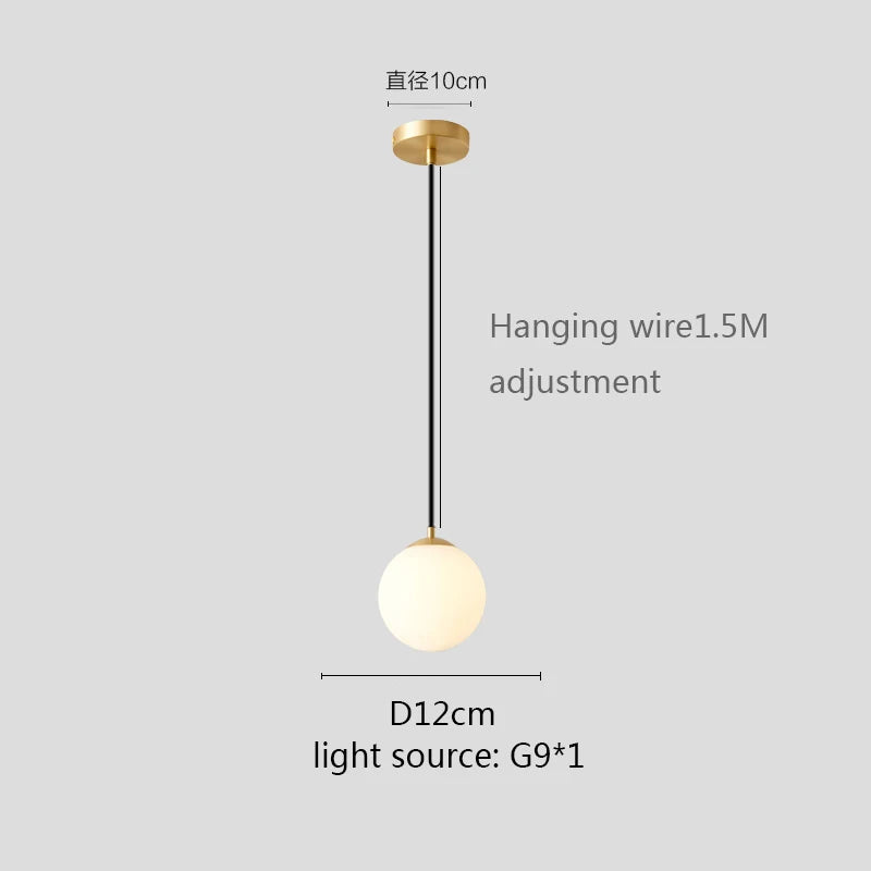Modern glass globe pendant light with gold finish hanging above a contemporary dining table.