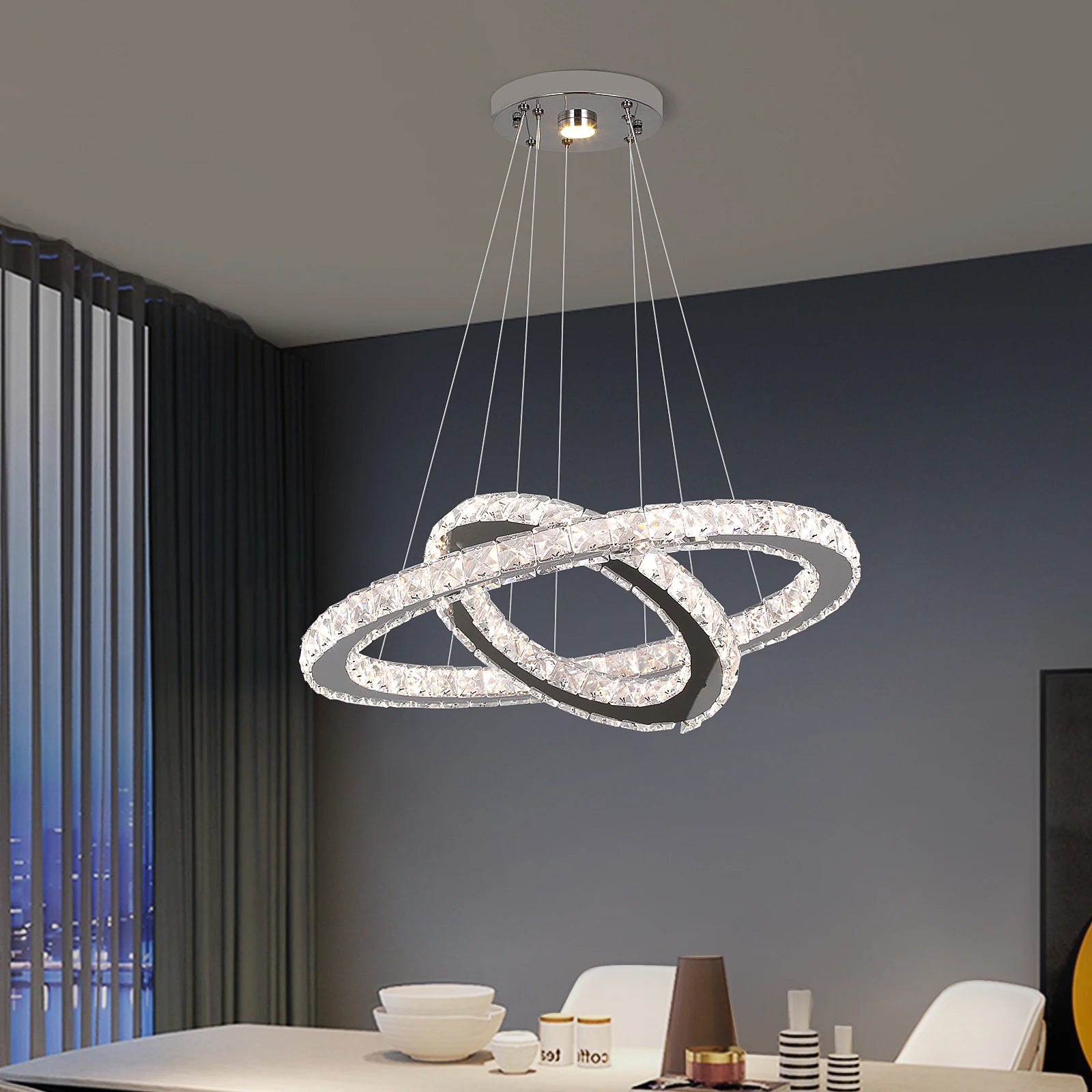 Luxury crystal ring LED chandelier suspended above a modern dining table in an elegant contemporary home.