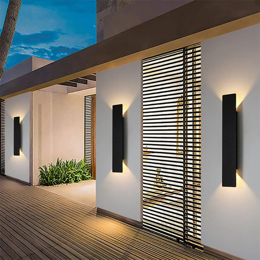 Modern black aluminum IP65 waterproof LED wall light mounted on an exterior wall with an up-and-down lighting effect.