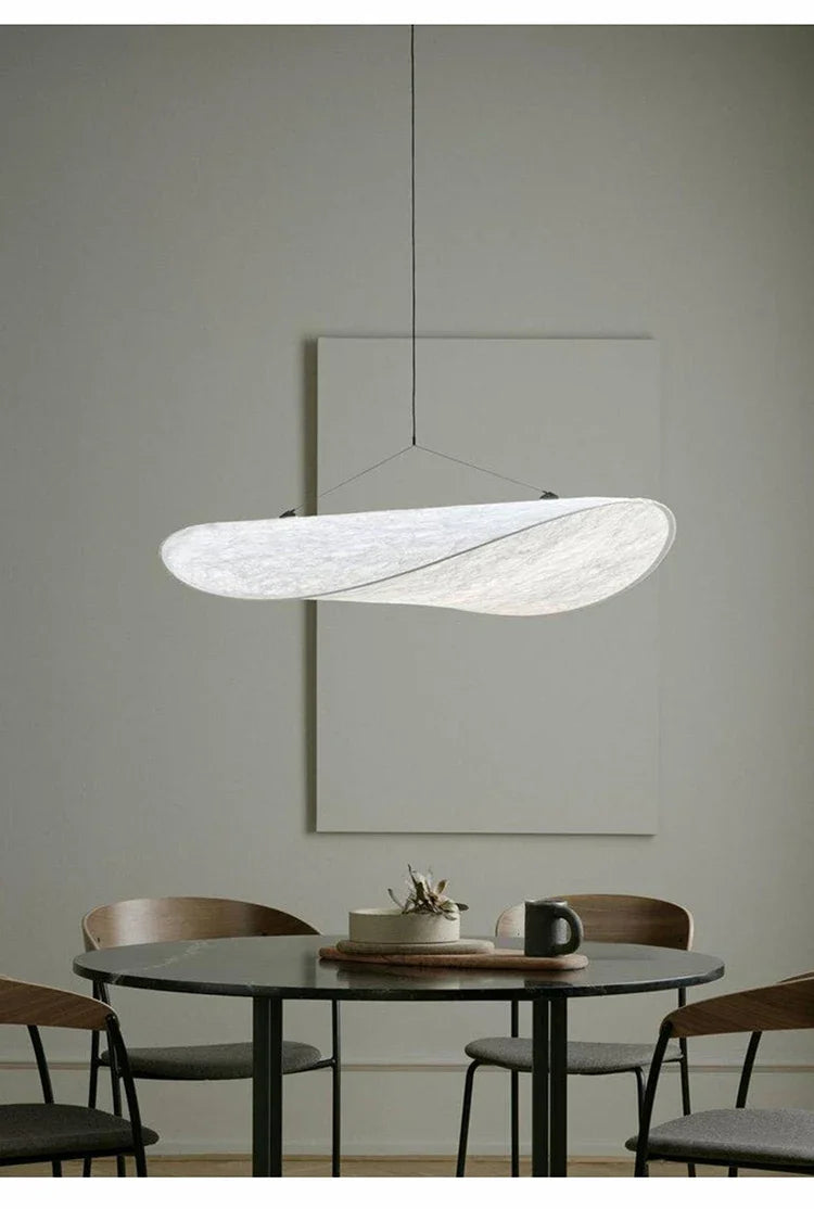 Nordic modern LED pendant light hanging above a dining table in a contemporary living room.