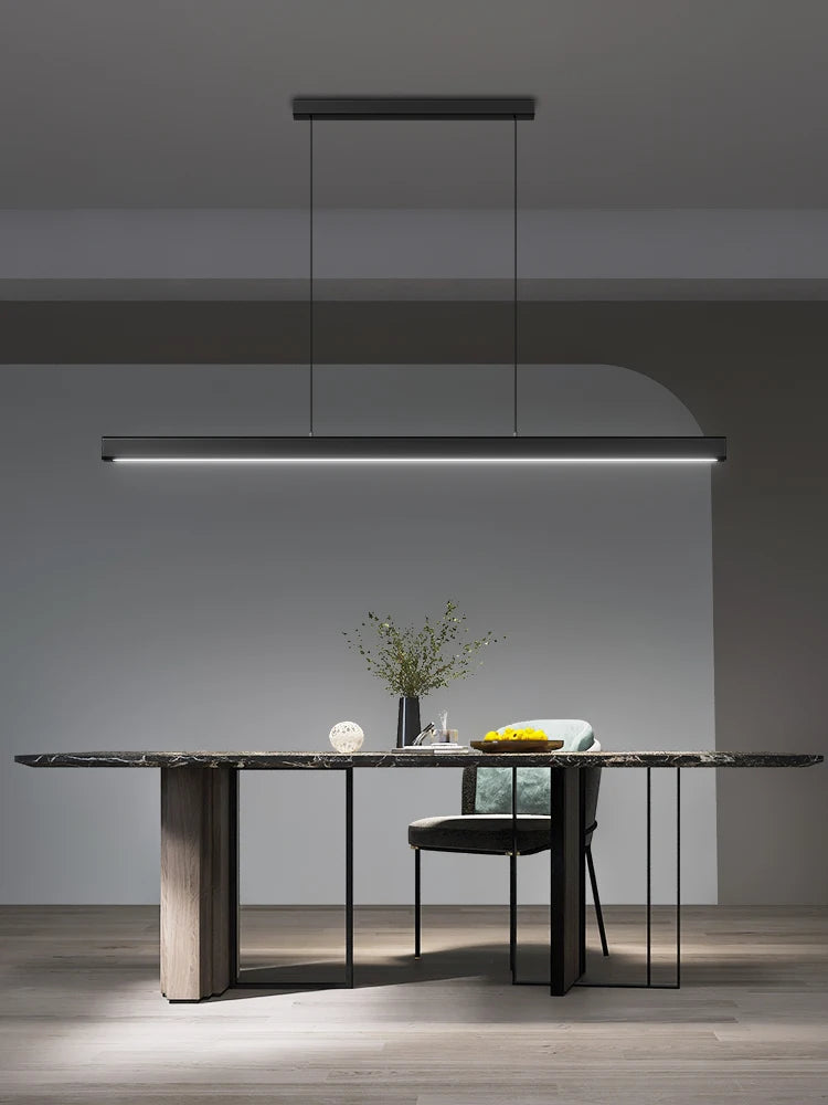 Modern linear LED pendant light suspended above a dining table in a contemporary dining room.