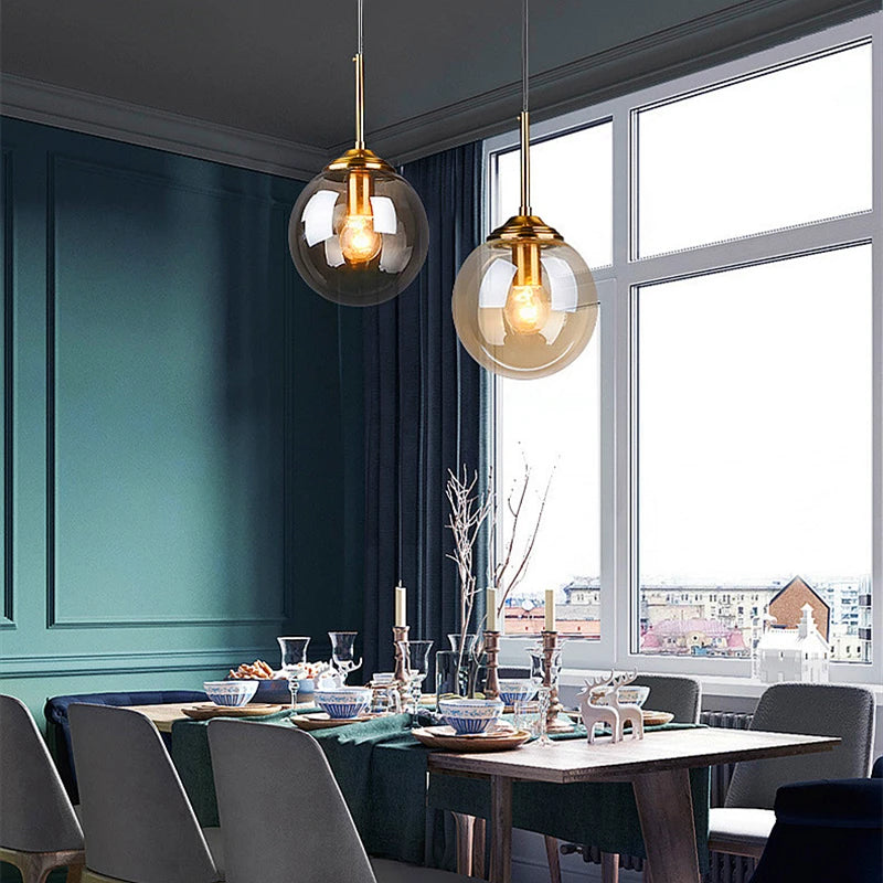 Modern luxury glass LED pendant light hanging above a dining table in a contemporary home.