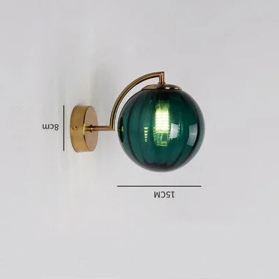 Modern Nordic glass LED wall sconce mounted beside a bed in a contemporary bedroom with warm ambient lighting.
