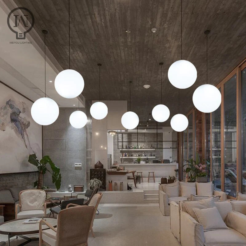 Modern Glass Globe Pendant Light illuminating a stylish dining area with comfortable seating and modern decor.