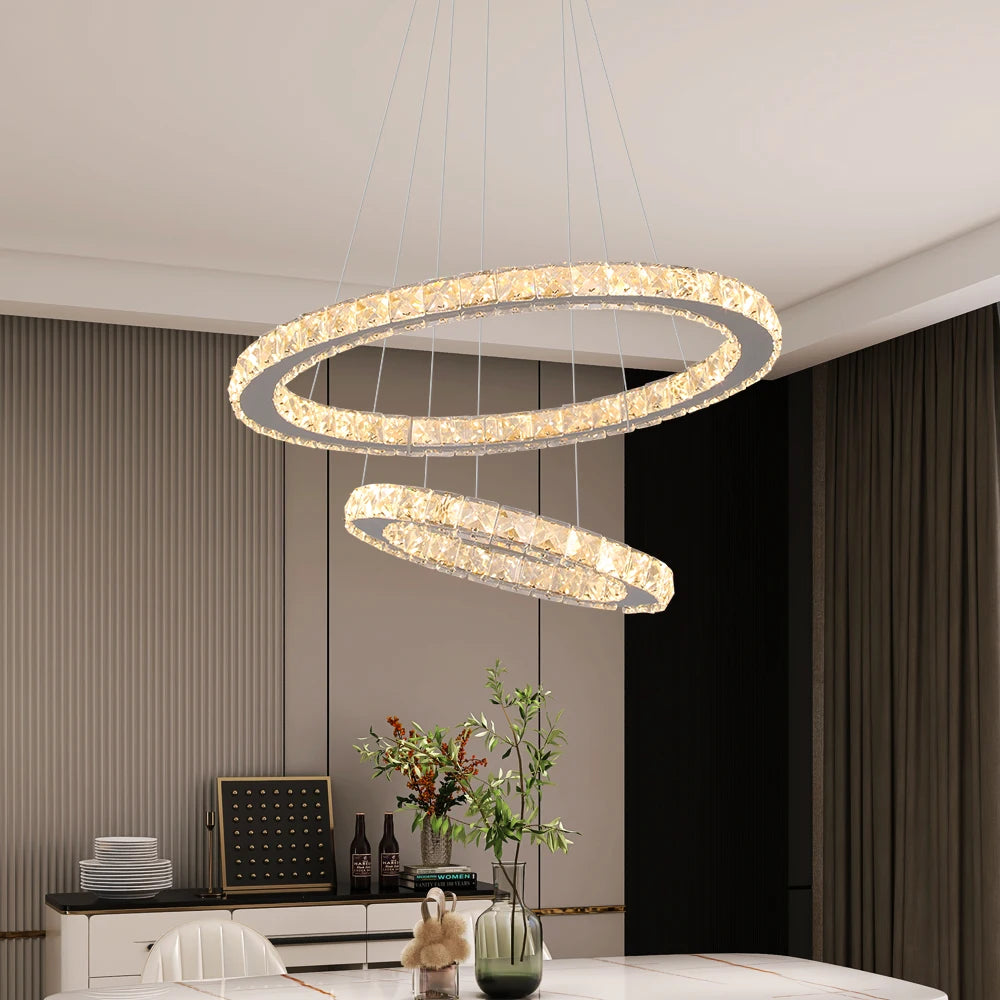 Luxury crystal ring LED chandelier suspended above a modern dining table in an elegant contemporary home.