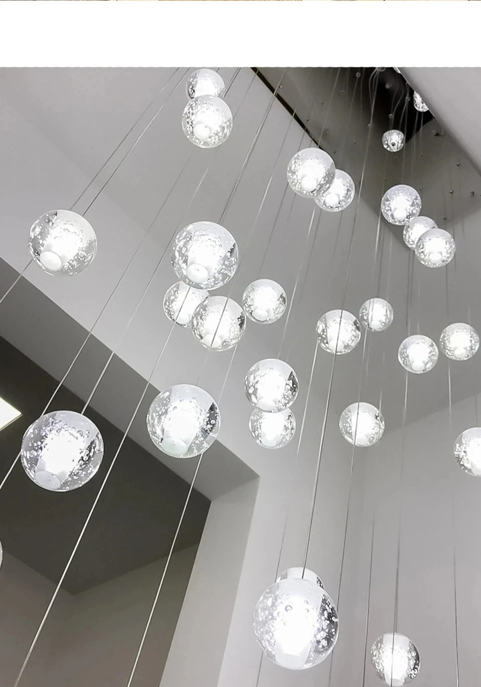 Modern spiral crystal LED chandelier cascading down a luxury staircase in a contemporary home.