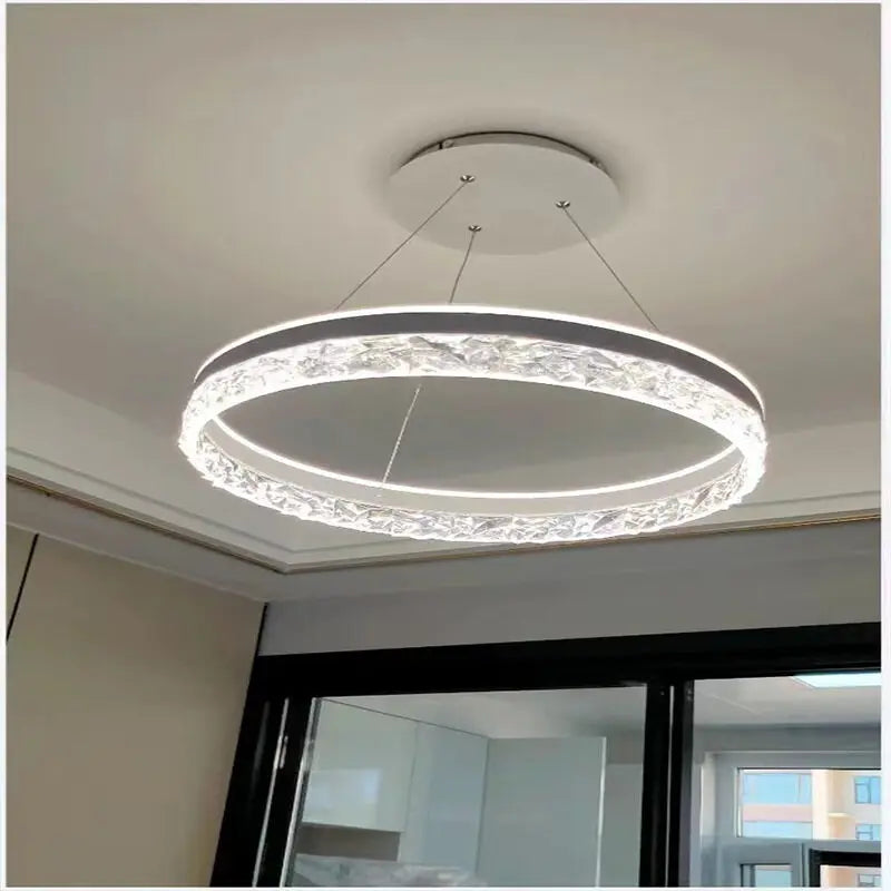 Modern luxe LED ring chandelier suspended in a contemporary living room with elegant minimalist décor.