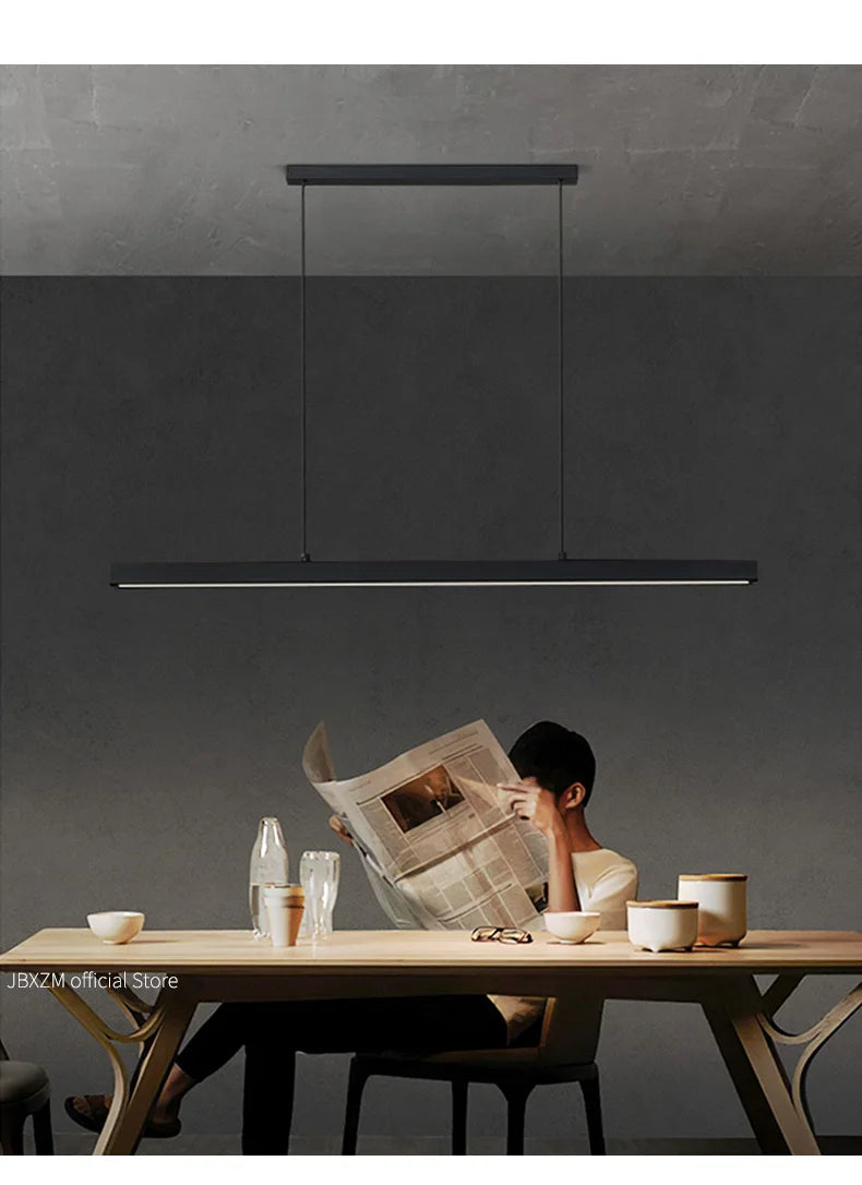 Modern linear LED pendant light suspended above a dining table in a contemporary dining room.