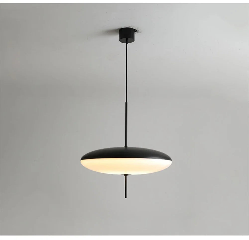Nordic flying saucer LED pendant light hanging in a modern living room with minimalist décor.