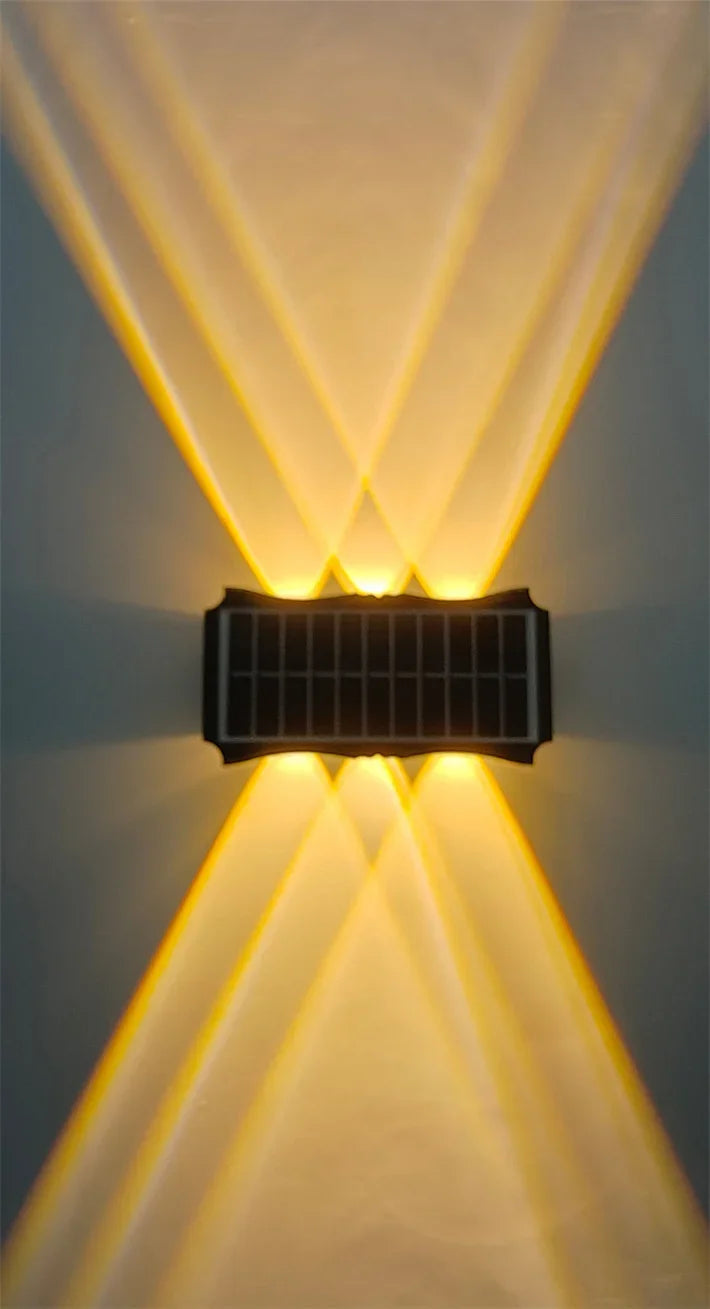 Modern waterproof solar LED wall light installed on an exterior wall illuminating a garden pathway.