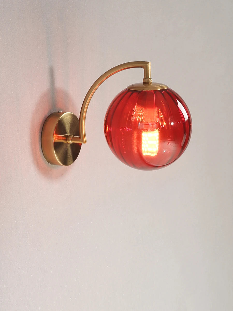 Modern Nordic glass LED wall sconce mounted beside a bed in a contemporary bedroom with warm ambient lighting.