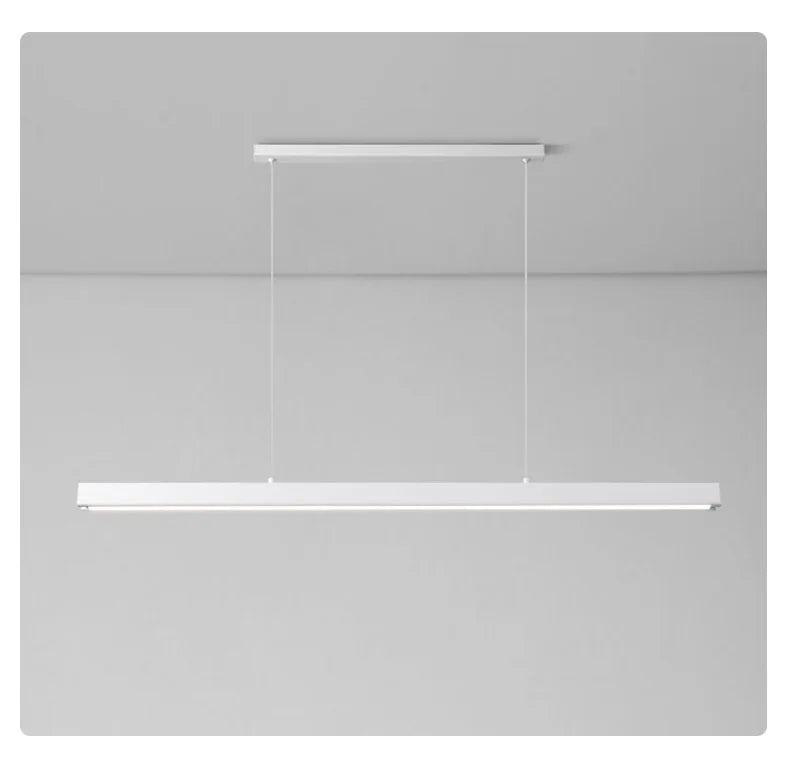 Modern linear LED pendant light suspended above a dining table in a contemporary dining room.