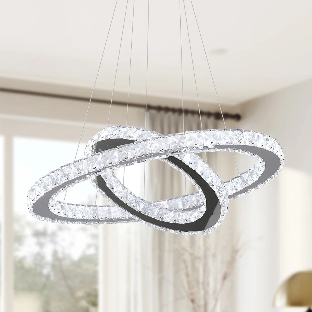 Luxury crystal ring LED chandelier suspended above a modern dining table in an elegant contemporary home.