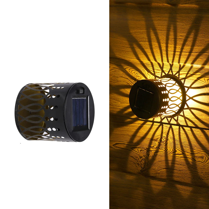 Modern waterproof solar projection LED wall light casting a decorative light pattern on an outdoor garden wall.