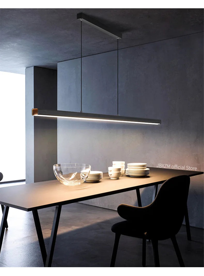 Modern linear LED pendant light suspended above a dining table in a contemporary dining room.
