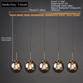 Modern luxury glass LED pendant light hanging above a dining table in a contemporary home.