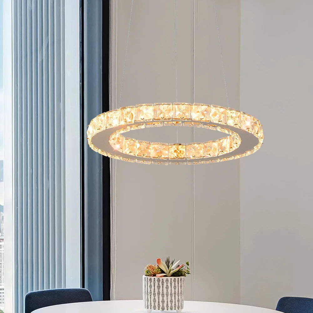 Luxury crystal ring LED chandelier suspended above a modern dining table in an elegant contemporary home.