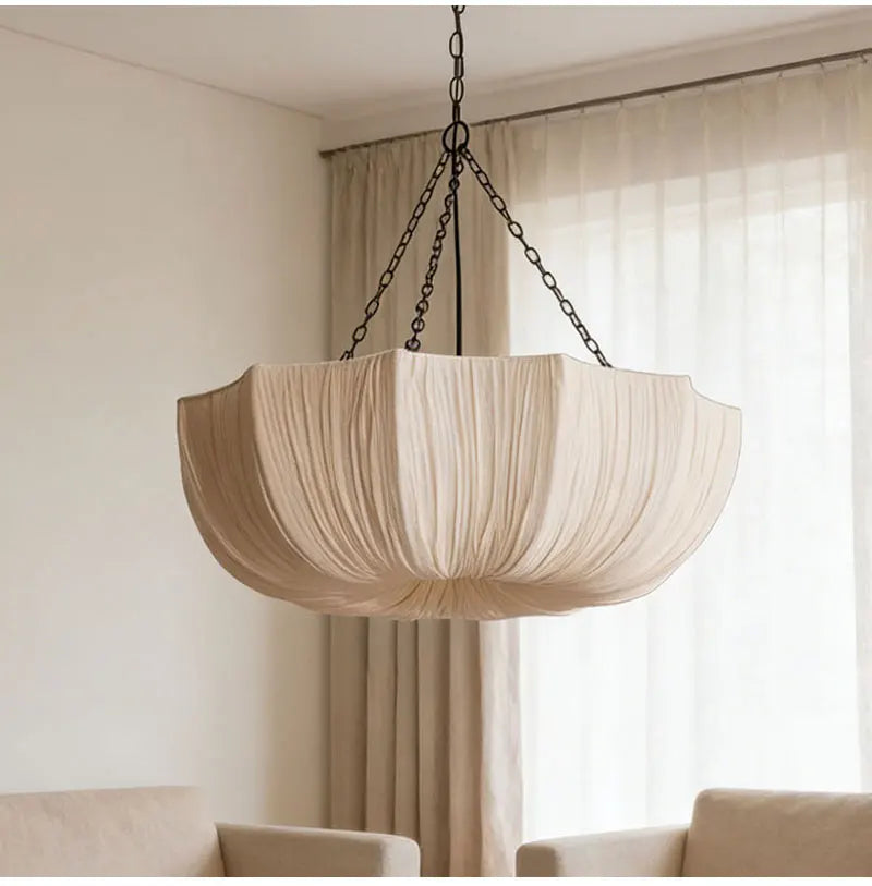 Japanese fabric pendant light with iron chain hanging above a modern dining table in a Japandi-style home.
