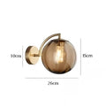 Modern Nordic glass LED wall sconce mounted beside a bed in a contemporary bedroom with warm ambient lighting.